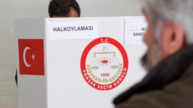 Ein Türke steht am 27.03.2017 in München (Bayern) in einem Wahllokal in der Wahlkabine.