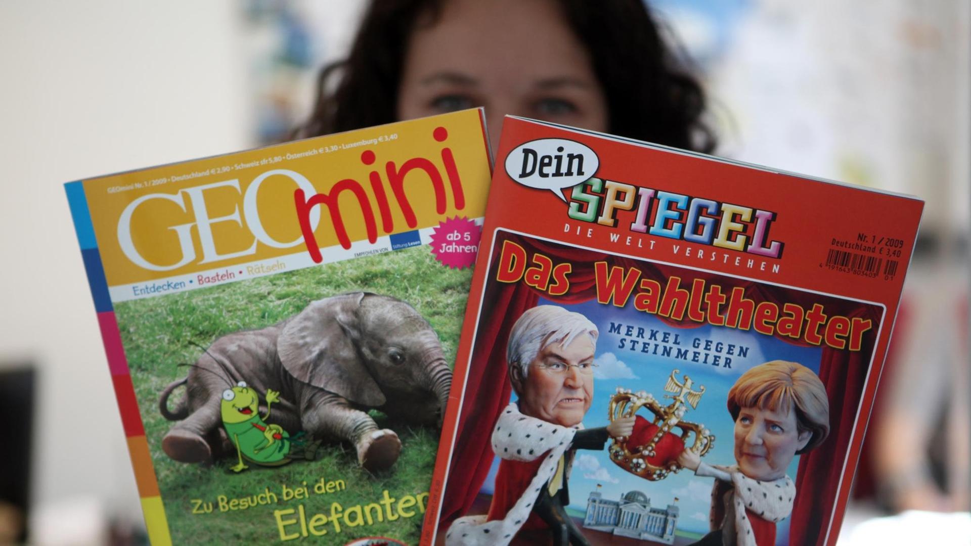 Eine Mitarbeiterin zeigt in Hamburg die neuen Kinderzeitschriften "GEOmini" und "Dein Spiegel".