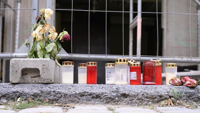 Blumen und Kerzen liegen zum Gedenken an das Opfer der Messerattacke unweit des Residenzschlosses vor einem Bauzaun an der Schlossstraße.