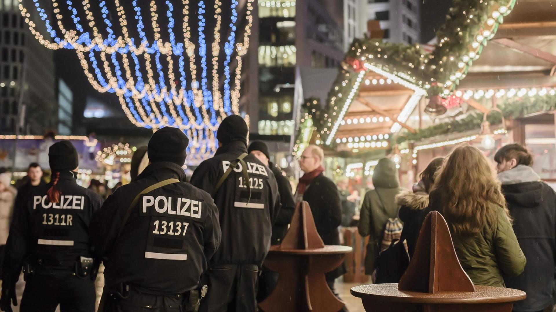 Polizisten laufen über den Weihnachtsmarkt am Berliner Breitscheidplatz.