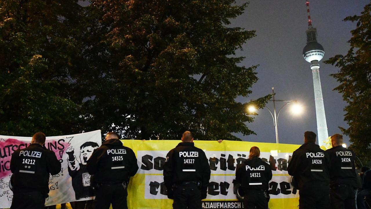 Polizisten stehen am 24.09.2017 in Berlin vor Demonstranten, die gegen die Partei Alternative für Deutschland (AfD) demonstrieren. Im Hintergrund ist der Fernsehturm zu sehen. Polizisten stehen am 24.09.2017 in Berlin vor Demonstranten, die gegen die Partei Alternative für Deutschland (AfD) demonstrieren. Im Hintergrund ist der Fernsehturm zu sehen.
