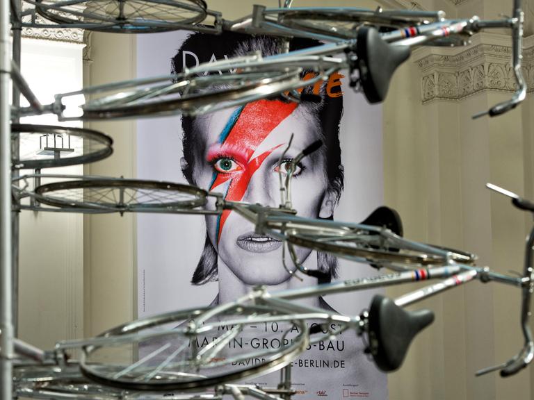 Das Plakat zur Ausstellung «David Bowie» hängt am 18.05.2014 im Vestibül des Martin-Gropius-Bau in Berlin hinter einer Fahrrad-Installation des chinesischen Künstlers Ai Weiwei.