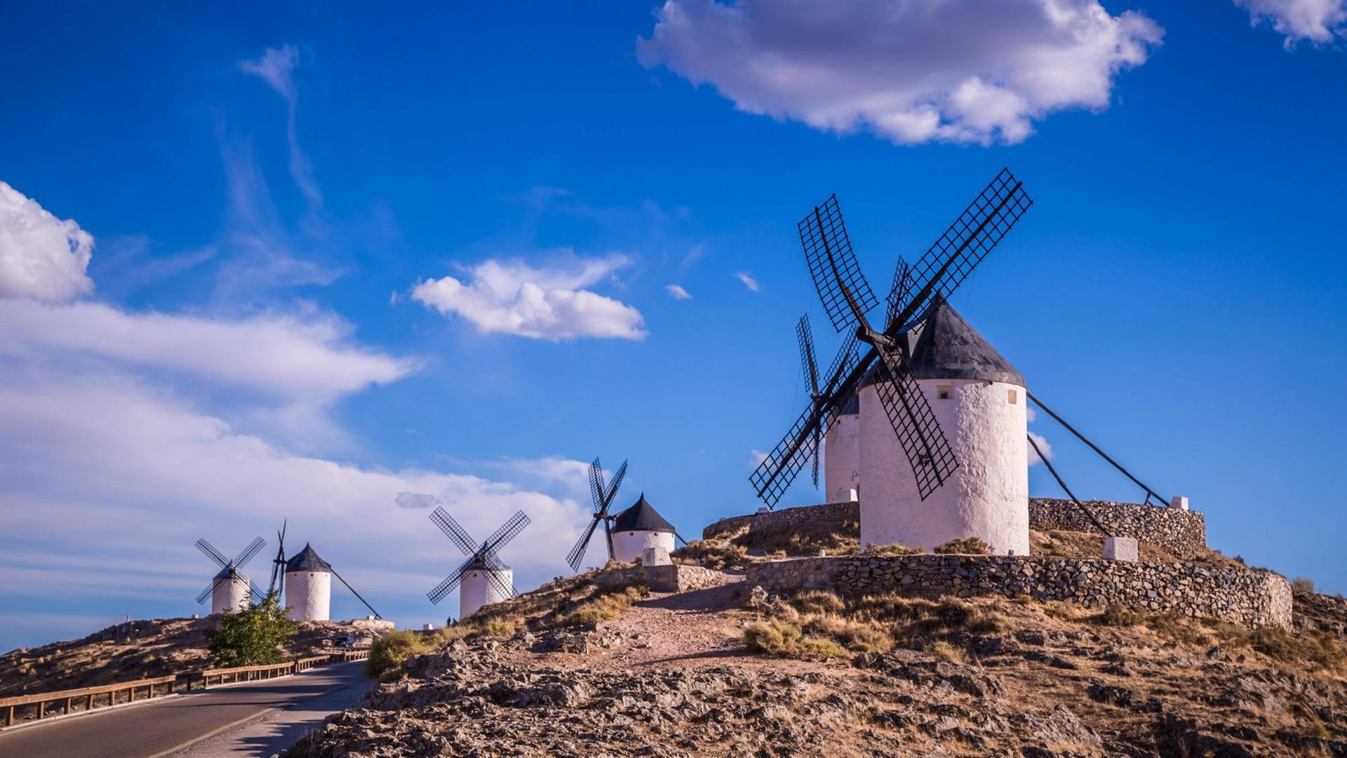 Mehrere Windmühlen stehen in einer Landschaft in Spanien
