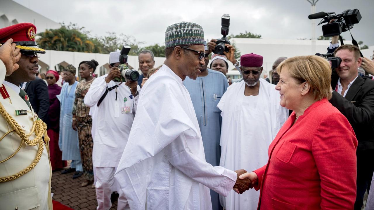 Nigeria, Abuja: Bundeskanzlerin Angela Merkel (CDU) wird von Muhammadu Buhari, Präsident der Bundesrepublik Nigeria, begrüßt