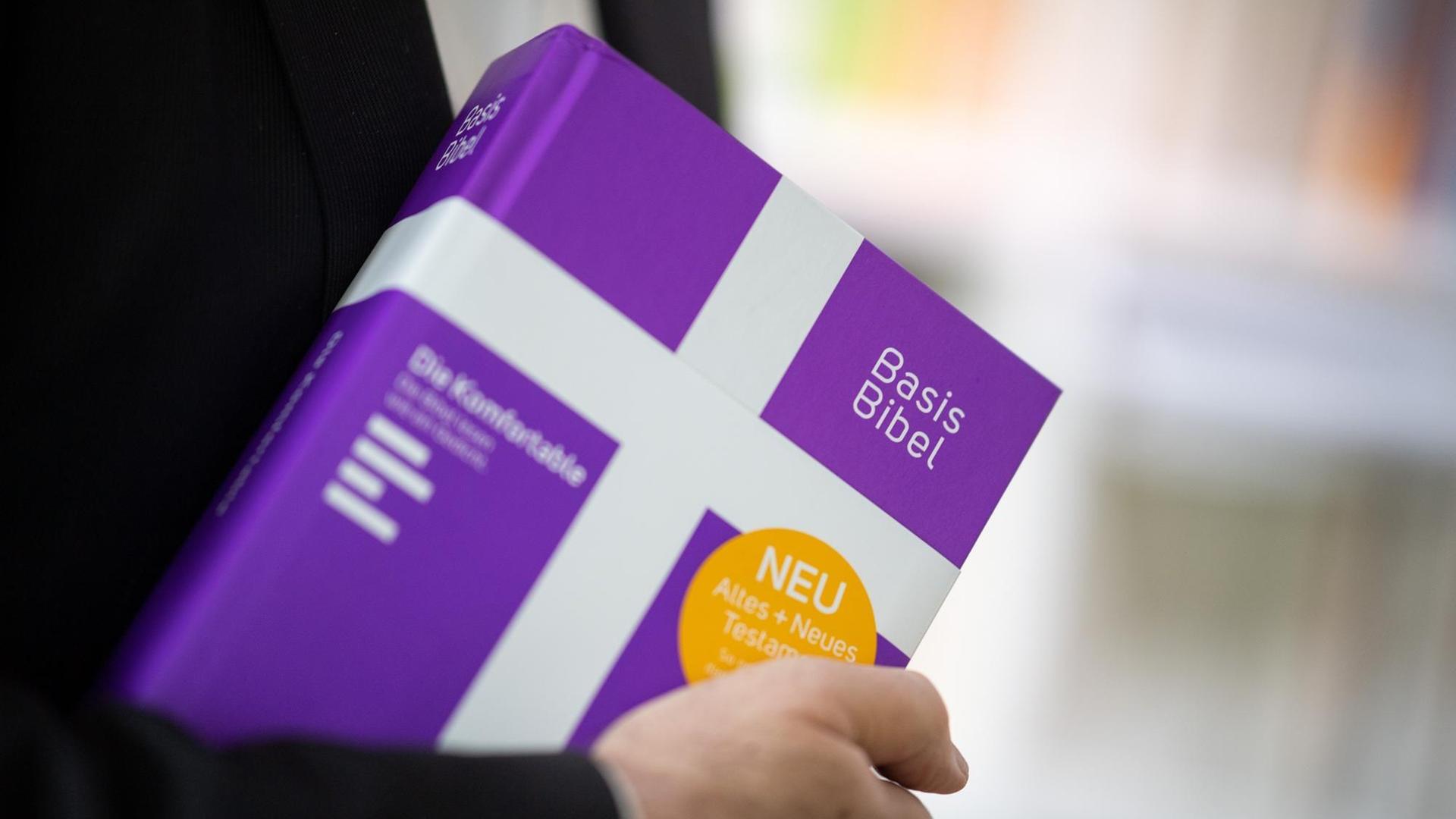 Frank Otfried July, Landesbischof der Evangelischen Kirche in Württemberg, hält eine Ausgabe der "BasisBibel" in der Hand. Die "BasisBibel" ist eine vollständige Ausgabe mit Altem und Neuem Testament. Laut Evangelischer Landeskirche handelt es sich um "eine neue Übersetzung der Bibel für das 21. Jahrhundert". Frank Otfried July, Landesbischof der Evangelischen Kirche in Württemberg, hält eine Ausgabe der "BasisBibel" in der Hand. Die "BasisBibel" ist eine vollständige Ausgabe mit Altem und Neuem Testament. Laut Evangelischer Landeskirche handelt es sich um "eine neue Übersetzung der Bibel für das 21. Jahrhundert".