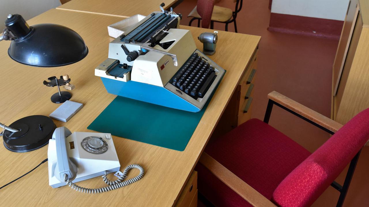 Blick in ein Erzieherzimmer mit Schreibmaschine, Telefon, Tischlampe, Stempel und Stiftanspitzer im ehemaligen DDR-Gefängnis der Gedenkstätte Zuchthaus Cottbus vom Verein Menschenrechtszentrum in Cottbus (Brandenburg). Blick in ein Erzieherzimmer mit Schreibmaschine, Telefon, Tischlampe, Stempel und Stiftanspitzer im ehemaligen DDR-Gefängnis der Gedenkstätte Zuchthaus Cottbus vom Verein Menschenrechtszentrum in Cottbus (Brandenburg).