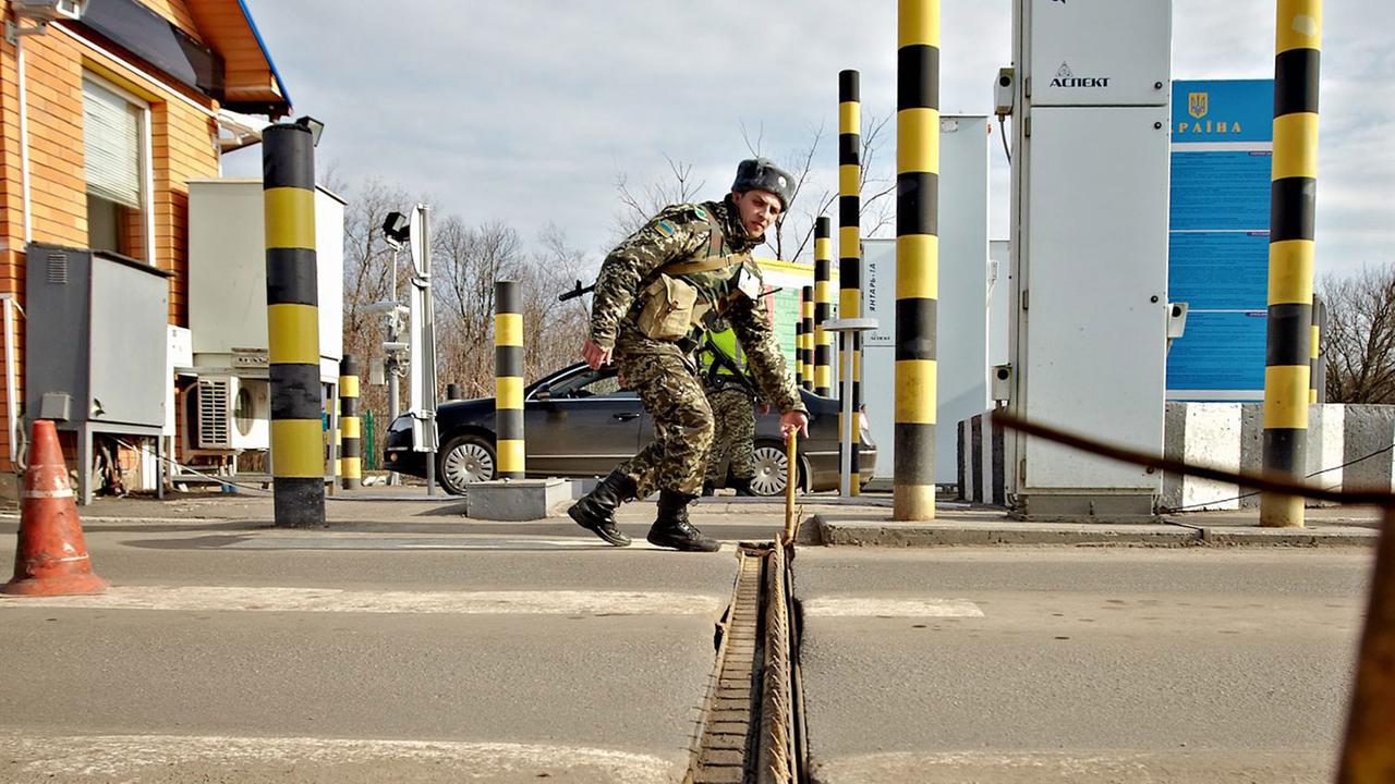 Ein ukrainischer Grenzbeamter errichtet eine Sperre an der russisch-ukrainischen Grenze in der Nähe des Ortes Goptivka. Ein ukrainischer Grenzbeamter errichtet eine Sperre an der russisch-ukrainischen Grenze in der Nähe des Ortes Goptivka.