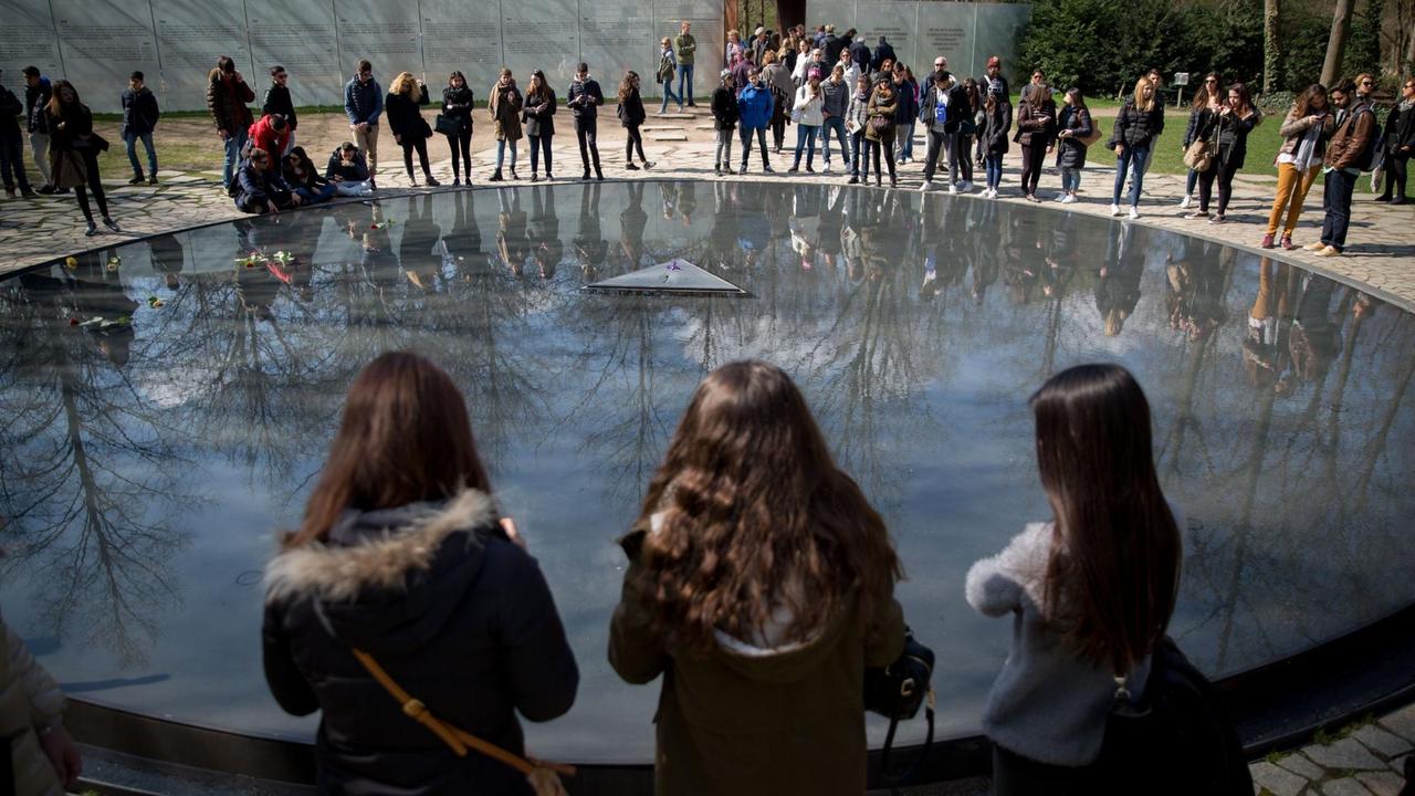 Schüler stehen am 08.04.2016 in Berlin an der Gedenkstätte für die in der Zeit des Nationalsozialismus ermordeten Sinti und Roma. Das Denkmal liegt im Tiergarten direkt neben dem Bundestag und wurde nach einem Entwurf des Künstlers Dani Karavan gestaltet. Im Rahmen des "Roma Day" bitten Sinti und Roma um Solidarität in Europa. Schüler stehen am 08.04.2016 in Berlin an der Gedenkstätte für die in der Zeit des Nationalsozialismus ermordeten Sinti und Roma. Das Denkmal liegt im Tiergarten direkt neben dem Bundestag und wurde nach einem Entwurf des Künstlers Dani Karavan gestaltet. Im Rahmen des "Roma Day" bitten Sinti und Roma um Solidarität in Europa.