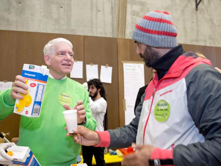 Der Präsident des Zentralrats der Juden, Schuster, verteilt im Rahmen des Mitzvah Day Essen an die Bewohner einer Flüchtlingsunterkunft in Berlin.