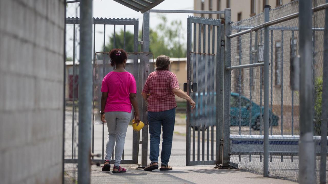 Bewohner betreten am 25.07.2016 in Aschaffenburg (Bayern) den gut gesicherten Eingang einer Flüchtlingsunterkunft des Freistaates Bayern in einer ehemaligen Kaserne, in der zur Zeit über 400 Menschen untergebracht sind. Bewohner betreten am 25.07.2016 in Aschaffenburg (Bayern) den gut gesicherten Eingang einer Flüchtlingsunterkunft des Freistaates Bayern in einer ehemaligen Kaserne, in der zur Zeit über 400 Menschen untergebracht sind.