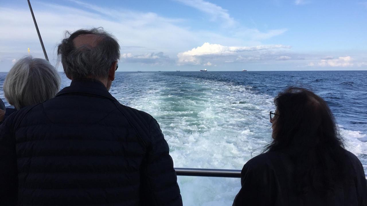 Passagiere stehen an der Reling und blicken auf das Meer. Passagiere stehen an der Reling und blicken auf das Meer.