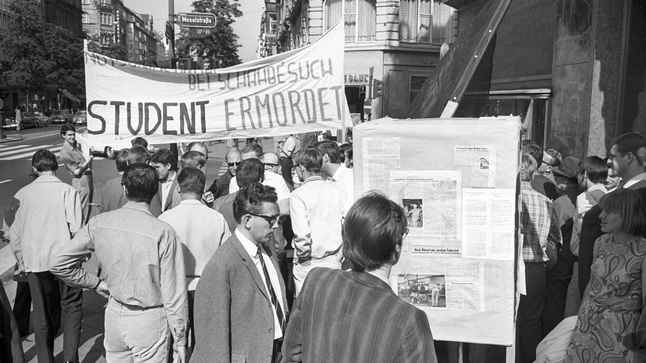 Am 06.06.1967 startete die AStA in Frankfurt am Main eine Informationskampagne zum Tode Benno Ohnesorgs. An rund 20 Plätzen wurden in der Innenstadt Informationsstände aufgebaut und Studenten, die zum Zeichen iher Trauer schwarze Armbinden trugen, stellten sich als Diskussionspartner zur Verfügung. Sie zeigtenTransparente und Schilder, hier mit der Aufschrift: "Bei Schahbesuch, Student ermordet". Am 06.06.1967 startete die AStA in Frankfurt am Main eine Informationskampagne zum Tode Benno Ohnesorgs. An rund 20 Plätzen wurden in der Innenstadt Informationsstände aufgebaut und Studenten, die zum Zeichen iher Trauer schwarze Armbinden trugen, stellten sich als Diskussionspartner zur Verfügung. Sie zeigtenTransparente und Schilder, hier mit der Aufschrift: "Bei Schahbesuch, Student ermordet".