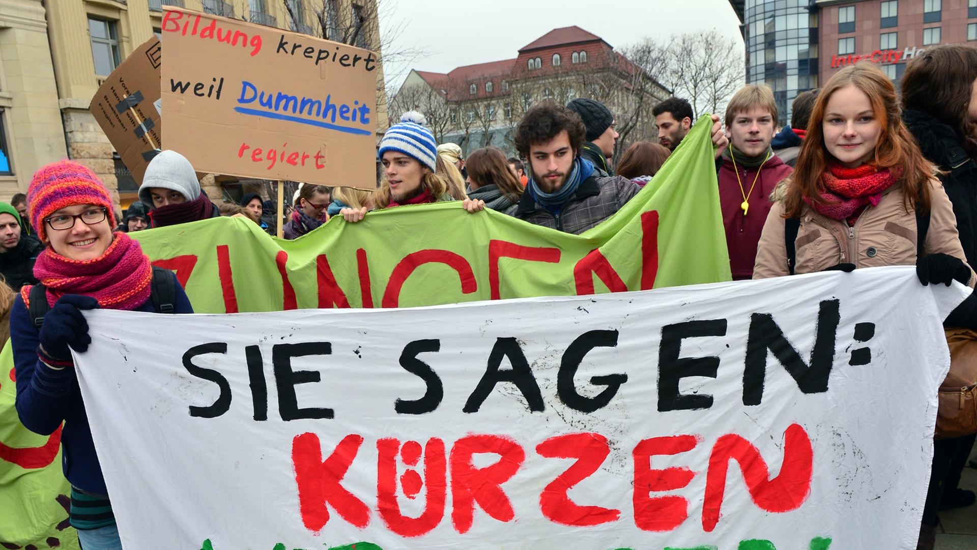 Thüringer Studenten demonstrieren am 11.12.2013 in Erfurt (Thüringen) und fordern mehr Geld für ihre Hochschulen. Sie halten ein Plakat in den Händen auf dem "Sie sagen: Kürzen, Wir sagen: Stürzen" steht. Thüringer Studenten demonstrieren am 11.12.2013 in Erfurt (Thüringen) und fordern mehr Geld für ihre Hochschulen. Sie halten ein Plakat in den Händen auf dem "Sie sagen: Kürzen, Wir sagen: Stürzen" steht.