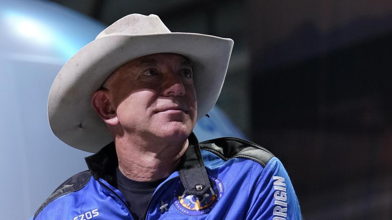 Ein Porträt von Amazon-Gründer Jeff Bezos. Der Unternehmer trägt einen blauen Overall und einen Cowboy-Hut. Ein Porträt von Amazon-Gründer Jeff Bezos. Der Unternehmer trägt einen blauen Overall und einen Cowboy-Hut.
