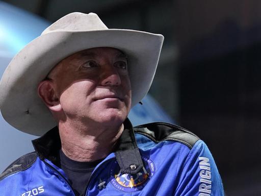 Ein Porträt von Amazon-Gründer Jeff Bezos. Der Unternehmer trägt einen blauen Overall und einen Cowboy-Hut. Ein Porträt von Amazon-Gründer Jeff Bezos. Der Unternehmer trägt einen blauen Overall und einen Cowboy-Hut.