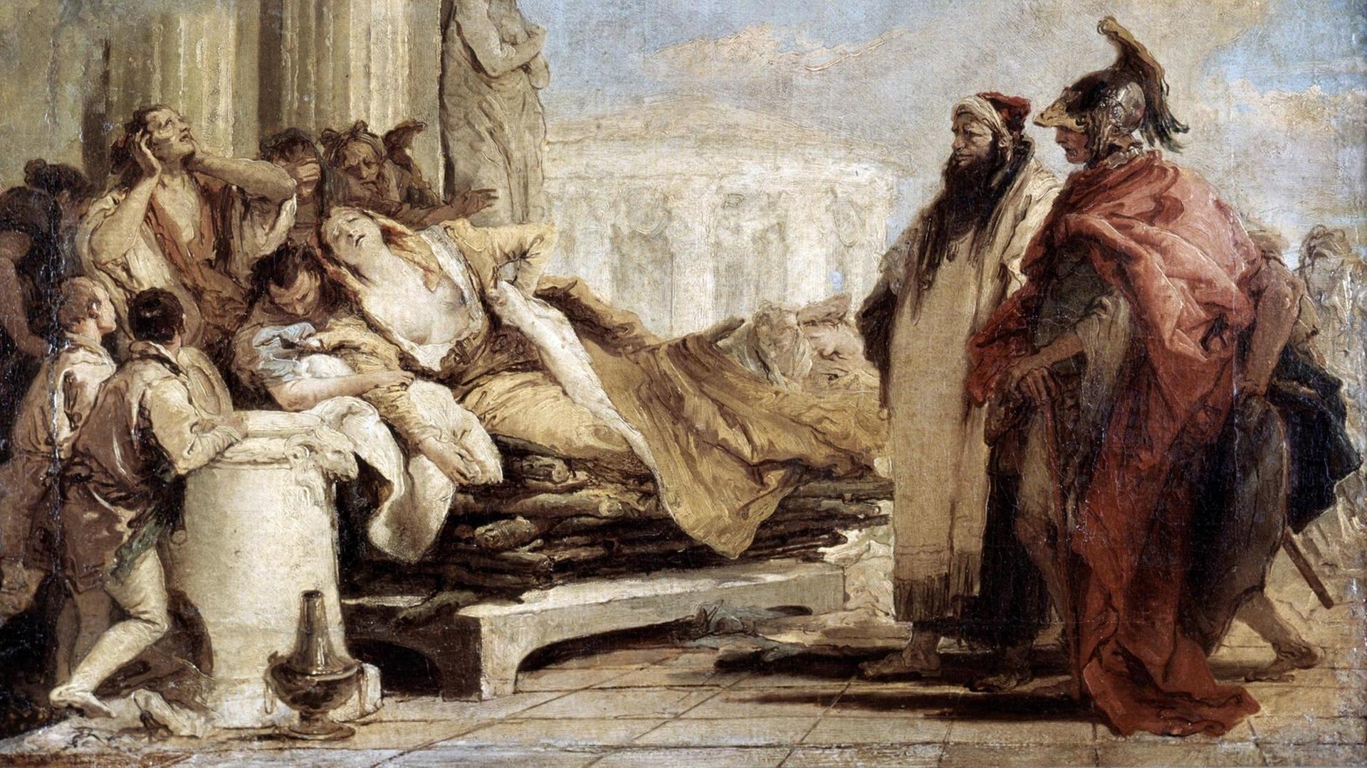 Eine aufgebahrte, sterbende Frau in einem antiken Setting, umringt von Männern