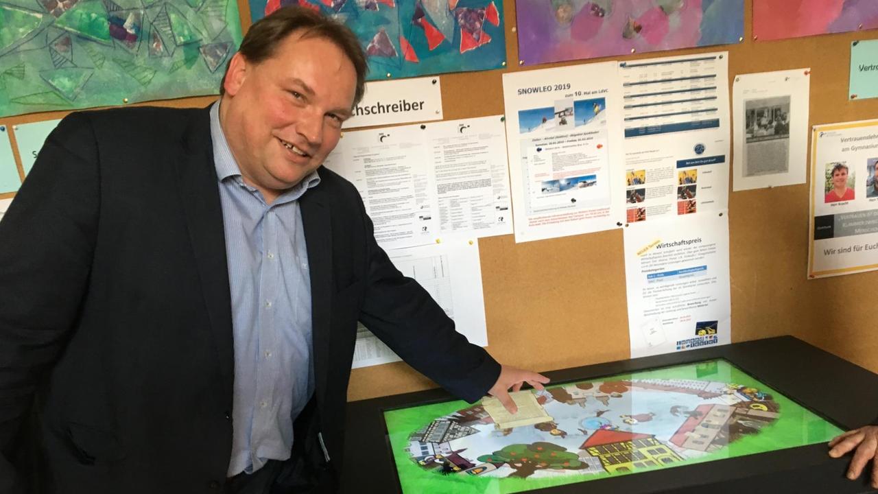 Olaf Gründel, Leiter Gymnasium Da Vinci Campus, steht in der Schule vor einem Touchscreen. Olaf Gründel, Leiter Gymnasium Da Vinci Campus, steht in der Schule vor einem Touchscreen.