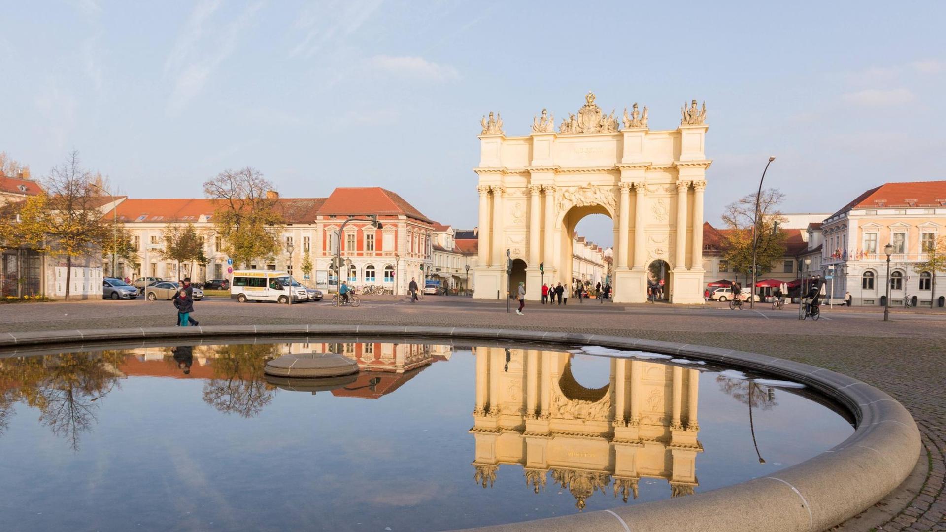 Brandenburger Tor in Potsdam spiegelt sich im Brunnen. Brandenburger Tor in Potsdam spiegelt sich im Brunnen.