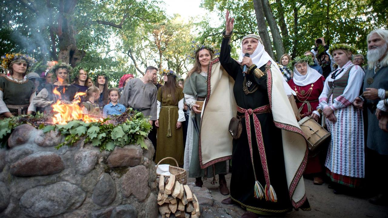 Frauen bei der Feuerzeremonie beim Rasos Festival. Sie tragen Blumenkränze und singen. Frauen bei der Feuerzeremonie beim Rasos Festival. Sie tragen Blumenkränze und singen.
