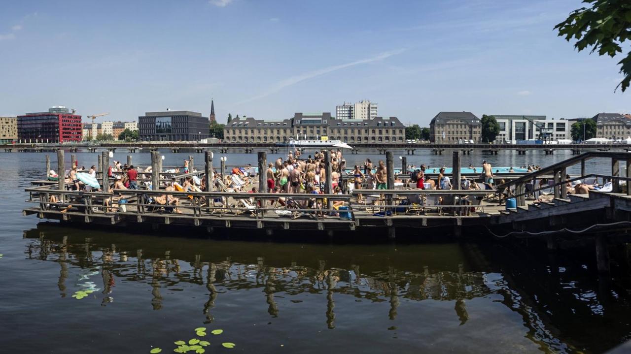 Auf der Spree befindet sich ein Schiff, auf dem Leute sich vergnügen. Im Hintergrund ist Friedrichshain zu sehen. Auf der Spree befindet sich ein Schiff, auf dem Leute sich vergnügen. Im Hintergrund ist Friedrichshain zu sehen.