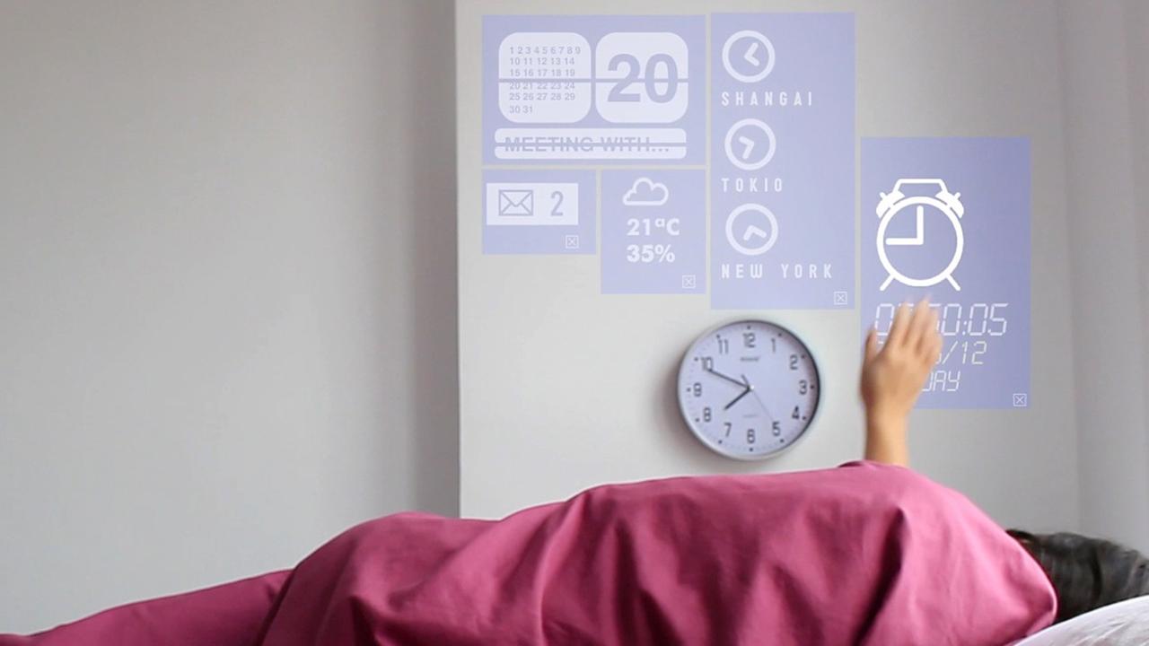 Eine Frau liegt in einem Bett und verändert mit einer Handbewegung das Licht. Die Technik wird in dem Prototyp eines Smart Home in Fuenterrabia in Spanien. Eine Frau liegt in einem Bett und verändert mit einer Handbewegung das Licht. Die Technik wird in dem Prototyp eines Smart Home in Fuenterrabia in Spanien.
