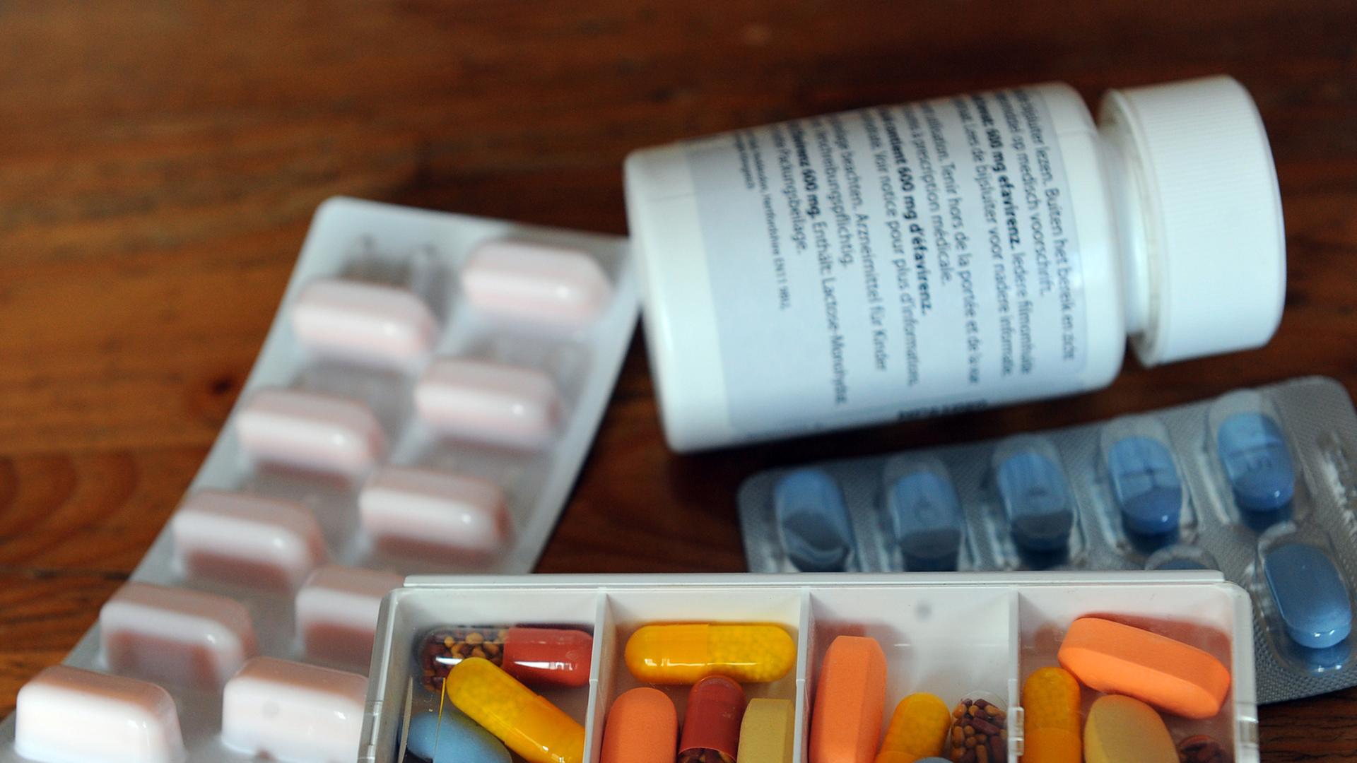 Tabletten eines an AIDS erkrankten Menschen liegen in Tagesrationen und in Blistern sowie einer Dose auf einem Tisch Tabletten eines an AIDS erkrankten Menschen liegen in Tagesrationen und in Blistern sowie einer Dose auf einem Tisch