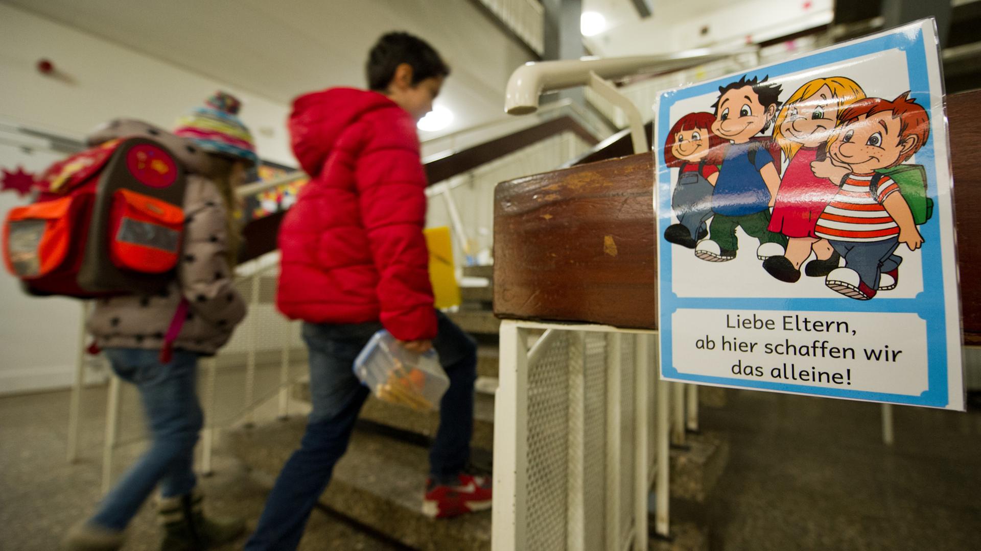 An einer Grundschule in Stuttgart laufen Schüler an einem Schild vorbei, das überfürsorgliche Eltern ermahnt, ihre Kinder alleine weitergehen zu lassen. An einer Grundschule in Stuttgart laufen Schüler an einem Schild vorbei, das überfürsorgliche Eltern ermahnt, ihre Kinder alleine weitergehen zu lassen.