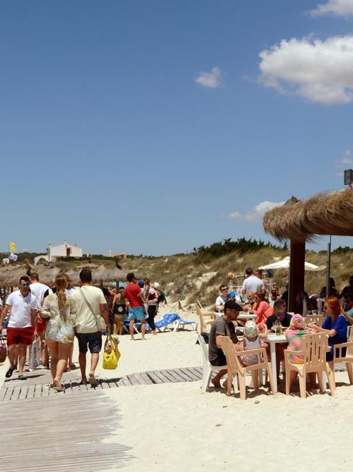 Touristen am Strand Es Trenc auf Mallorca.