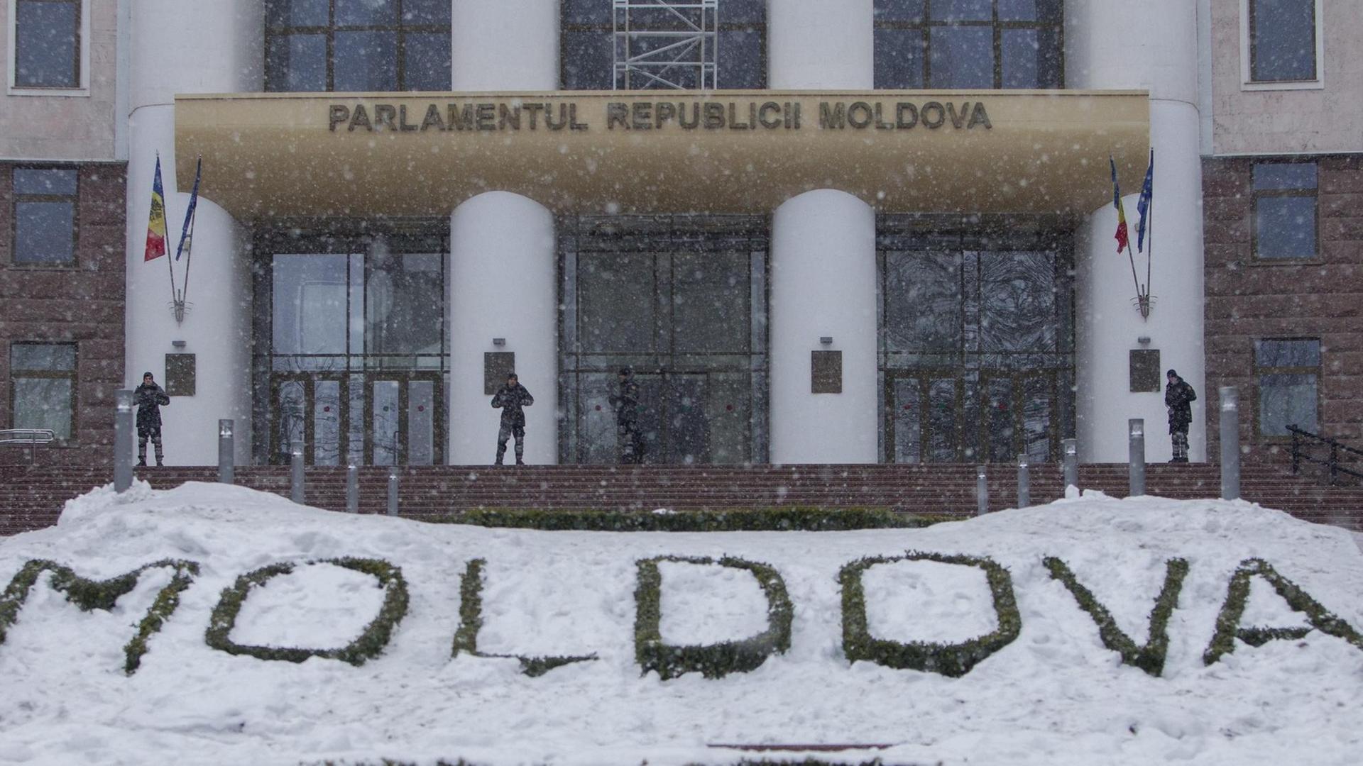 Wachmänner stehen vor dem Parlament in Chisinau, der Hauptstadt der ehemaligen Sowjetrepublik Moldau. Im Vordergrund ein in Stein gehauener Schriftzug Moldova, der teils von Schnee bedeckt ist. Wachmänner stehen vor dem Parlament in Chisinau, der Hauptstadt der ehemaligen Sowjetrepublik Moldau. Im Vordergrund ein in Stein gehauener Schriftzug Moldova, der teils von Schnee bedeckt ist.