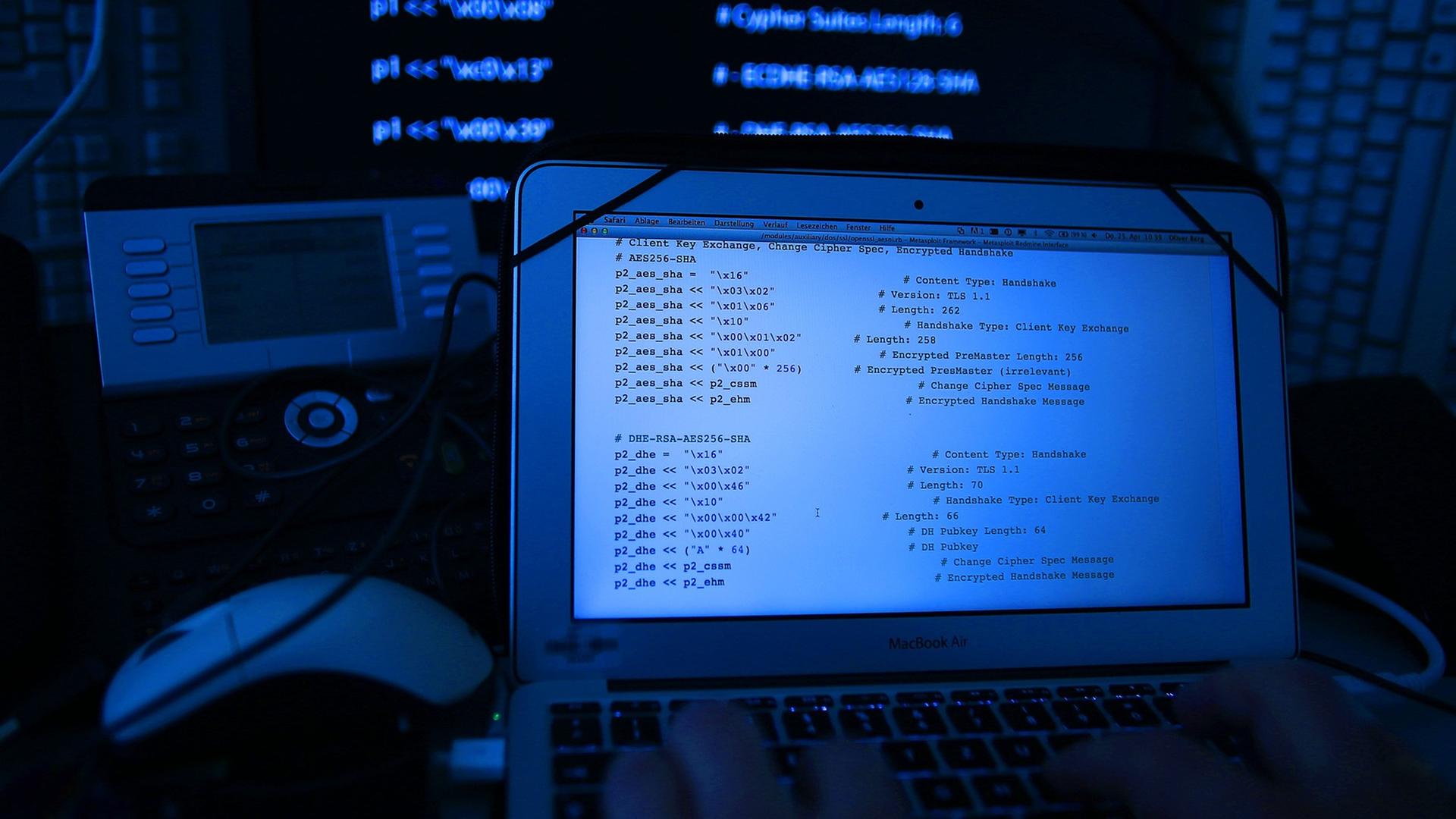 Ein Mann vor einem Rechner mit Quellcode auf dem Bildschirm. Ein Mann vor einem Rechner mit Quellcode auf dem Bildschirm.