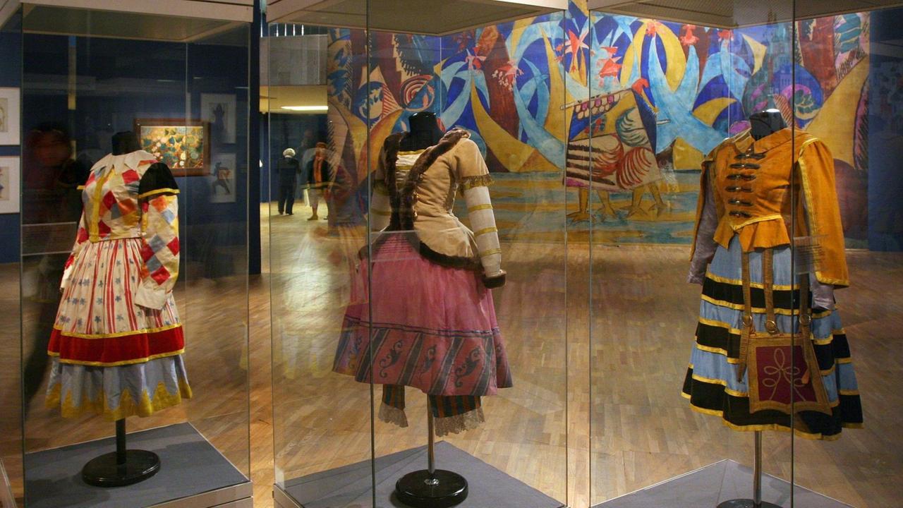 In Vitrinen sind drei der originalen Frauenkonstüme mit weiten Röcken und folkloriostischen Stoffen ausgestellt. In Vitrinen sind drei der originalen Frauenkonstüme mit weiten Röcken und folkloriostischen Stoffen ausgestellt.