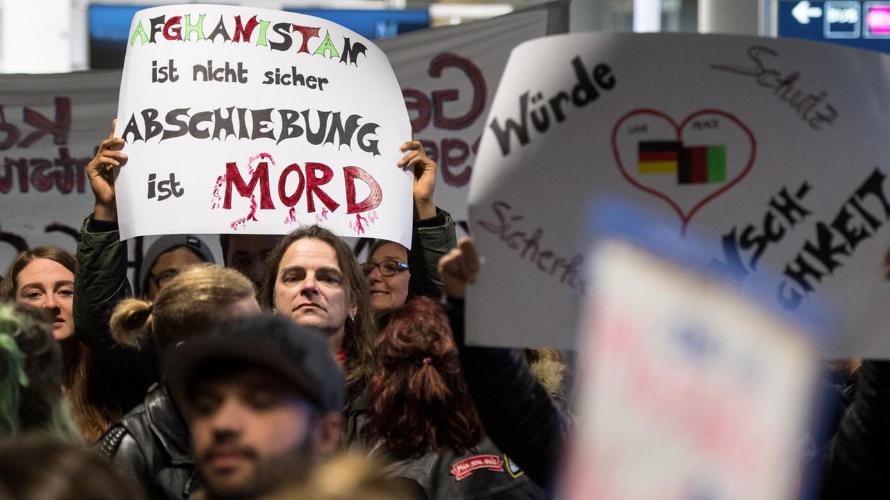 Einige der Demonstranten halten Schilder in die Höhe, auf einem ist "Abschiebung ist Mord" zu lesen. Einige der Demonstranten halten Schilder in die Höhe, auf einem ist "Abschiebung ist Mord" zu lesen.