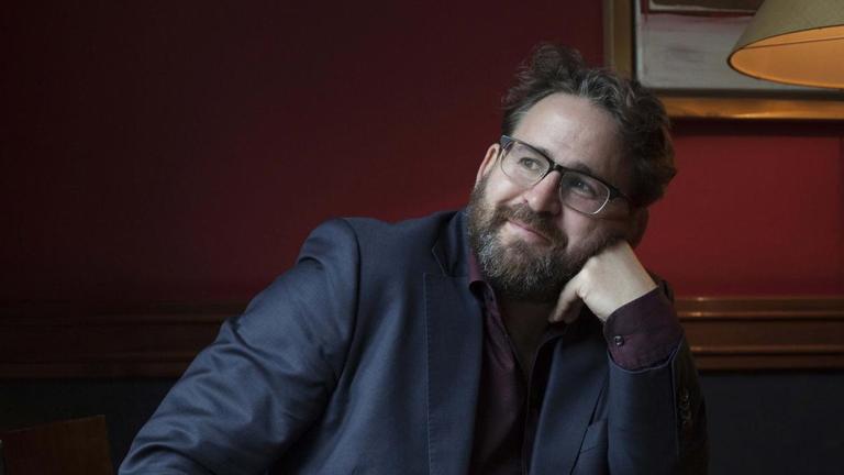 Der Autor und Philosoph Wolfram Eilenberger hat den Kopf auf die linke Hand gestützt und schaut nachdenklich schmunzelnd in die Höhe. Der Autor und Philosoph Wolfram Eilenberger hat den Kopf auf die linke Hand gestützt und schaut nachdenklich schmunzelnd in die Höhe.