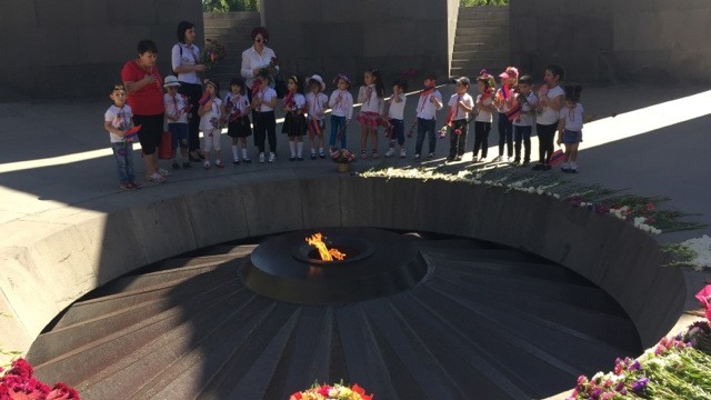 Kinder stehen an einem Denkmal