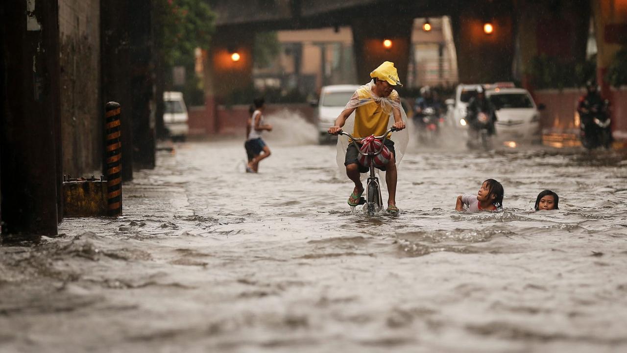 Heftiger Regen hat am 13.8.2016 in der philippinischen Hauptstadt Manila eine Straße überflutet. Heftiger Regen hat am 13.8.2016 in der philippinischen Hauptstadt Manila eine Straße überflutet.