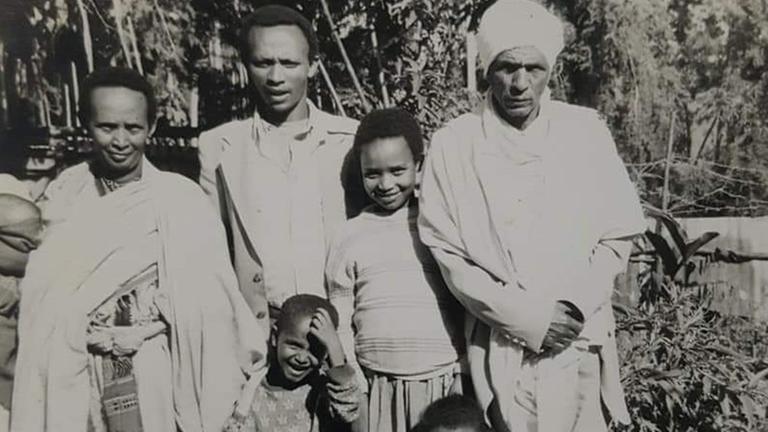 Die Schwarzweißfotografie zeigt eine schwarze Familie. Zu sehen sind Mutter, Vater (mit weißer Kopfbedeckung) und drei Söhne. Die Schwarzweißfotografie zeigt eine schwarze Familie. Zu sehen sind Mutter, Vater (mit weißer Kopfbedeckung) und drei Söhne.