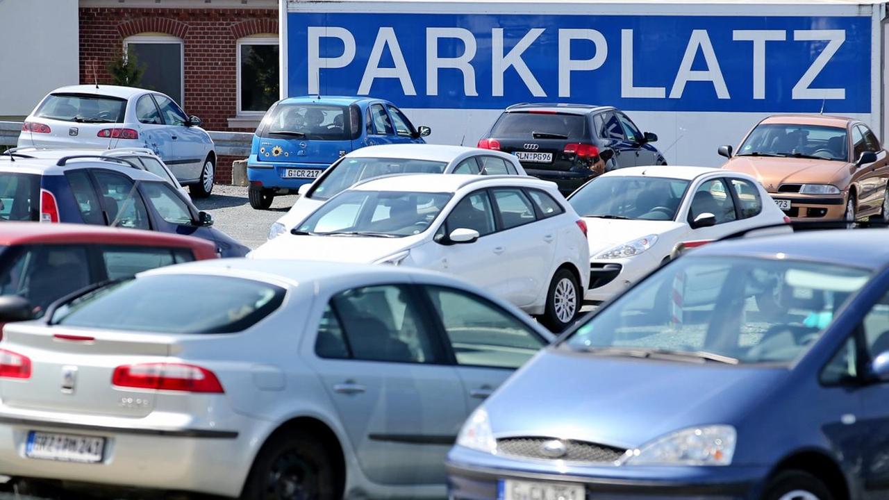 Ein überdimensionales Schild "Parkplatz" hängt am 29.04.2015 an einer Parkfläche für Pkw in Gera (Thüringen) Ein überdimensionales Schild "Parkplatz" hängt am 29.04.2015 an einer Parkfläche für Pkw in Gera (Thüringen)