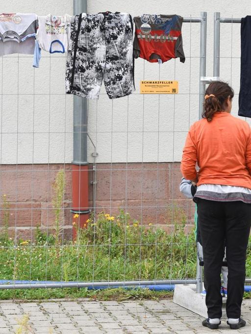 Eine Asylbewerberin hängt in einer Notunterkunft für Flüchtlinge in Heidelberg Wäsche auf.