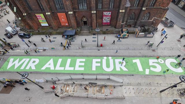 Aktivisten von Fridays for Future malen den Schriftzug «WIR ALLE FÜR 1,5 GRAD" auf die Mönckebergstraße. Fridays for Future Hamburg beteiligte sich am globalem Klimastreik unter dem Motto «#Alle für1Komma5».
