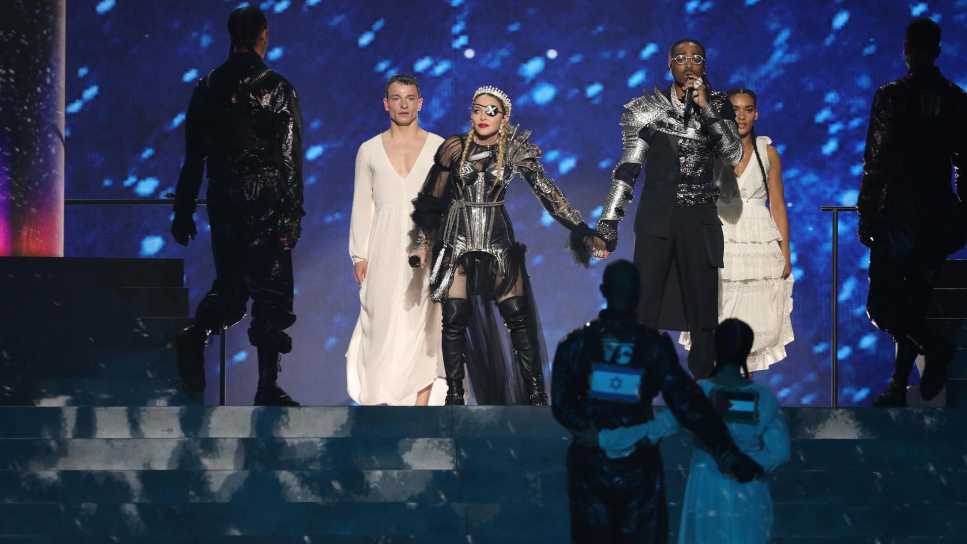 Madonna und Tänzer während ihres Auftritts beim Eurovision Song Contest. Der Tänzer und die Tänzerin tragen auf dem Rücken eine israelische und eine Palästinensische Flagge. Madonna und Tänzer während ihres Auftritts beim Eurovision Song Contest. Der Tänzer und die Tänzerin tragen auf dem Rücken eine israelische und eine Palästinensische Flagge.