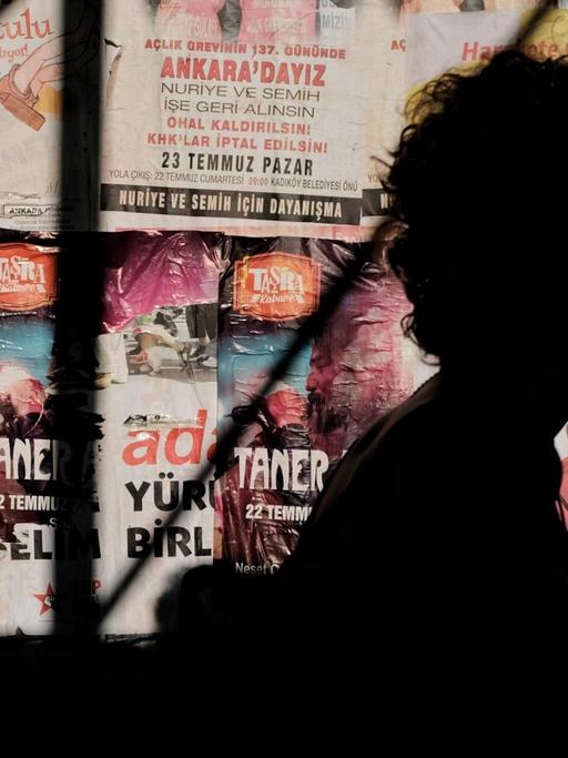 Silhouette eine Person vor einer Wand mit türkischen Postern.