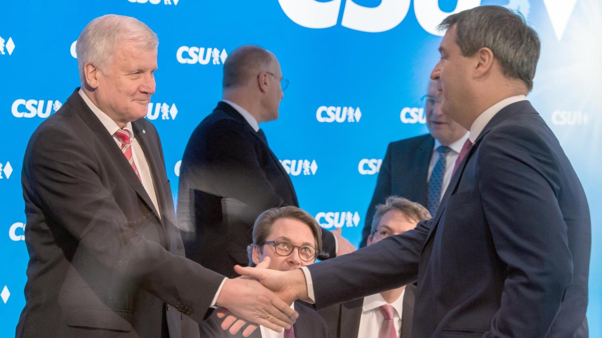 Der bayerische Ministerpräsident Horst Seehofer (l) und der bayerische Finanzminister Markus Söder (r) geben sich am 04.12.2017 in der CSU-Zentrale in München (Bayern) vor Beginn der Vorstandssitzung die Hand.
