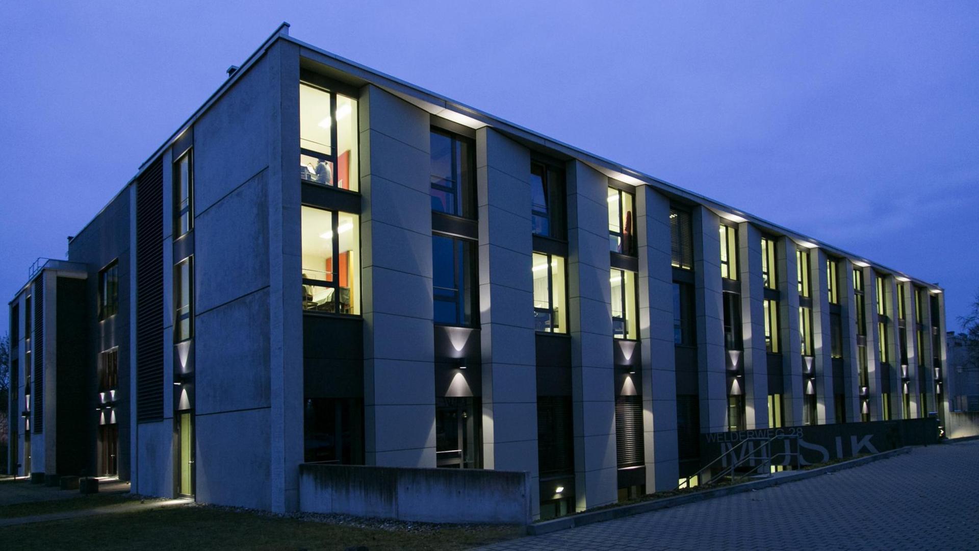 In einem modernen Würfelbau sind viele Fenster erleuchtet. In einem modernen Würfelbau sind viele Fenster erleuchtet.