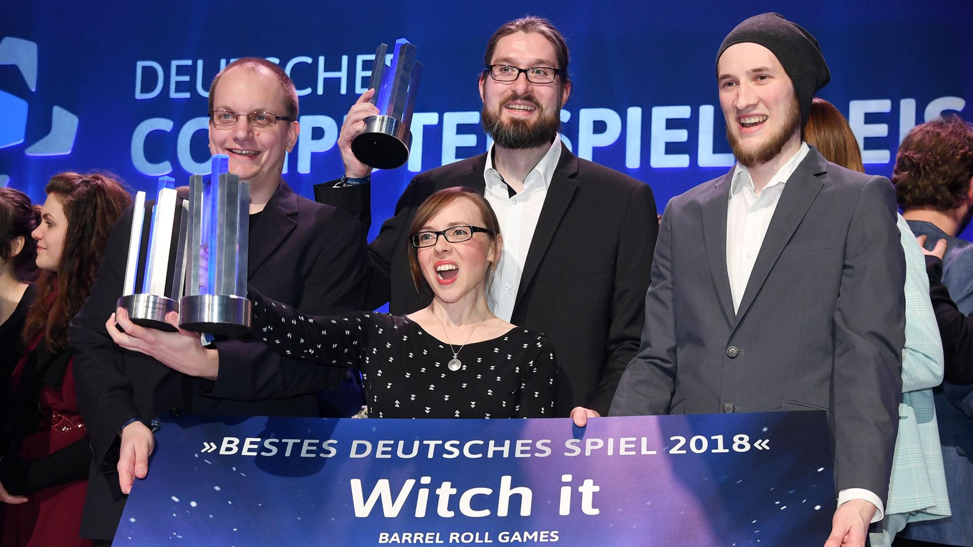Die Sieger in der Kategorie "Bestes Deutsches Spiel 2018" Nils Ohlig (l-r), Tina Heitmann, Christoph Rienäcker und Lukas Köhne stehen bei der Verleihung des Deutschen Computerspielpreises mit ihrem Scheck und ihren Auszeichnungen auf der Bühne. Die Preisträger der Unternehmen Barrel Roll Games und Daedalic Entertainment wurden für das Spiel Witch It in insgesamt drei Kategorien ausgezeichnet. Die Sieger in der Kategorie "Bestes Deutsches Spiel 2018" Nils Ohlig (l-r), Tina Heitmann, Christoph Rienäcker und Lukas Köhne stehen bei der Verleihung des Deutschen Computerspielpreises mit ihrem Scheck und ihren Auszeichnungen auf der Bühne. Die Preisträger der Unternehmen Barrel Roll Games und Daedalic Entertainment wurden für das Spiel Witch It in insgesamt drei Kategorien ausgezeichnet.