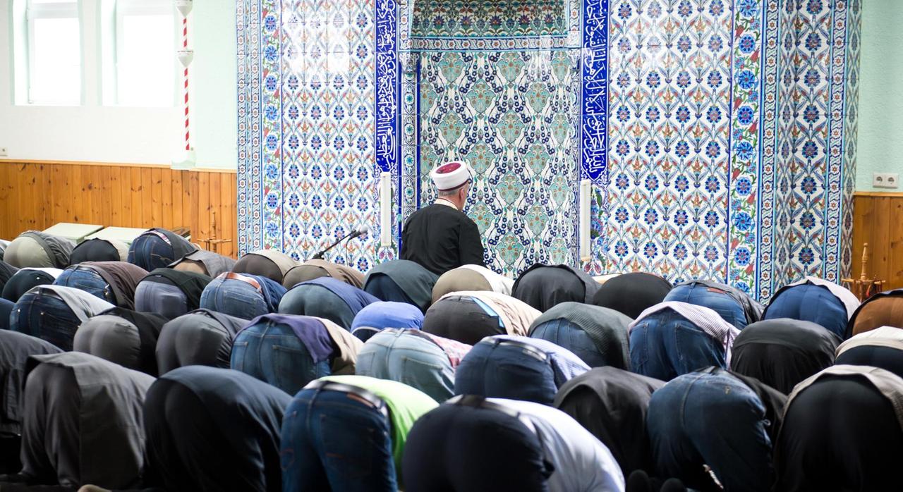 Sie sehen Muslime, die gemeinsam in einer Moschee beten.