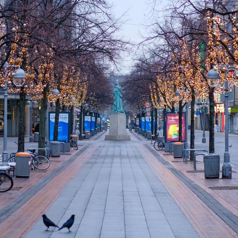 Zwei Tauben sitzen auf dem Pflaster in der Innenstadt von Hannover vor der Öffnung der Geschäfte. 