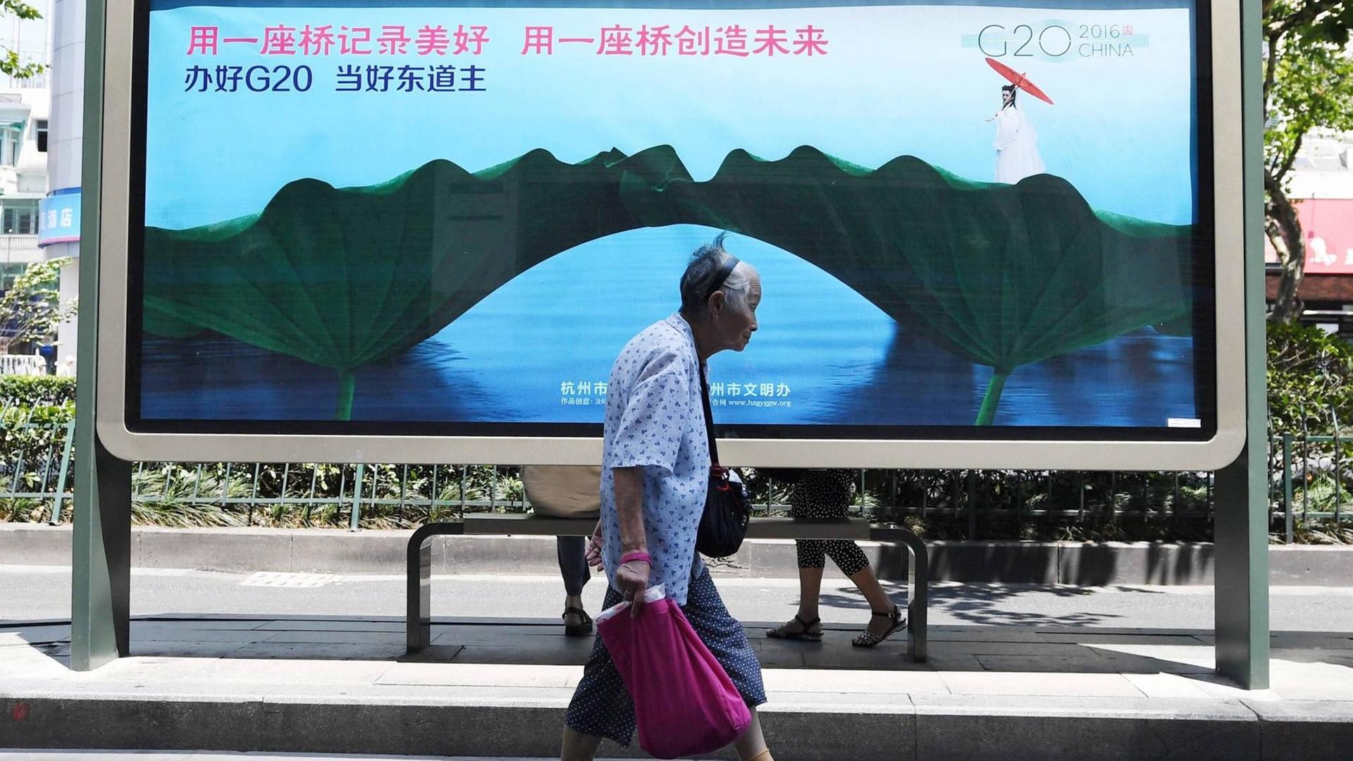Eine Frau geht vor einem Plakat zum G20-Gipfel in Hangzhou vorbei. Eine Frau geht vor einem Plakat zum G20-Gipfel in Hangzhou vorbei.