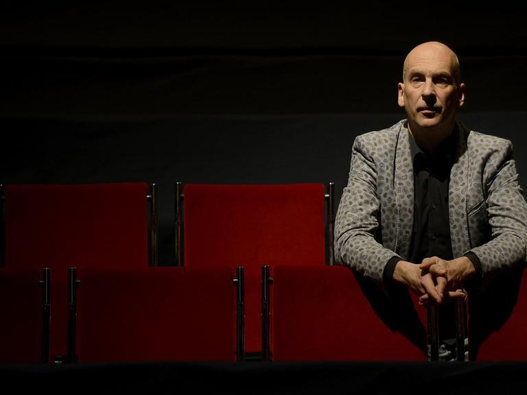 Der Theaterregisseur Volker Lösch während eines Interviewtermins im Zuschauerraum eines Theaters.