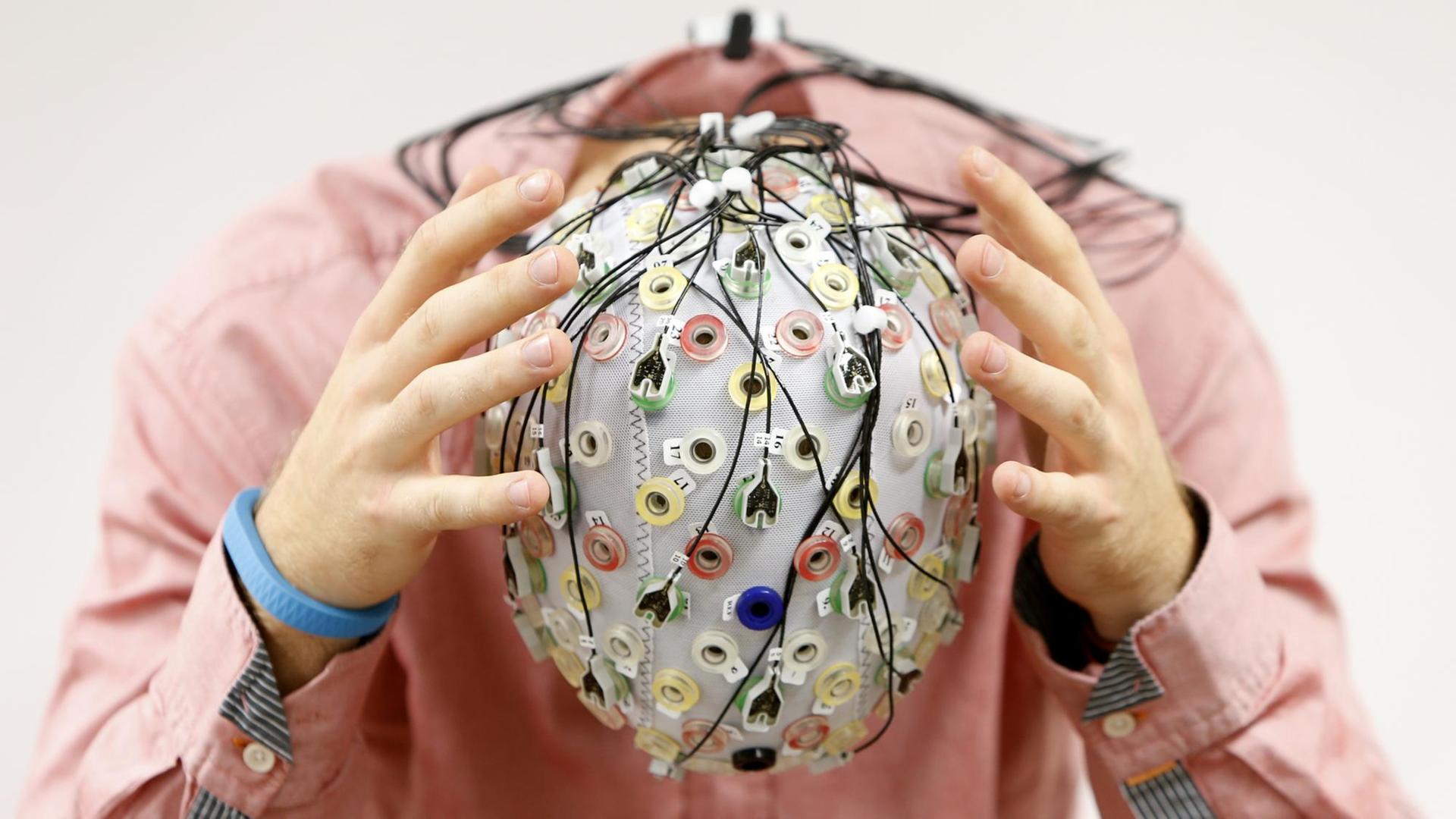 Ein Mann trägt eine EEG-Kappe Ein Mann trägt eine EEG-Kappe