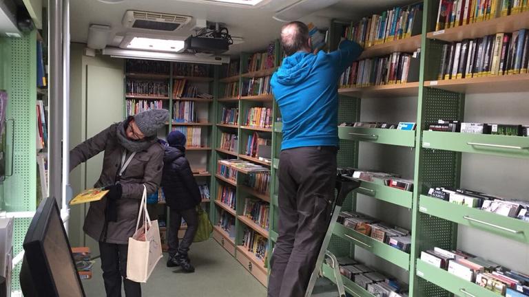 Innenansicht der Fahrbibliothek: Besucher durchsuchen die Regale